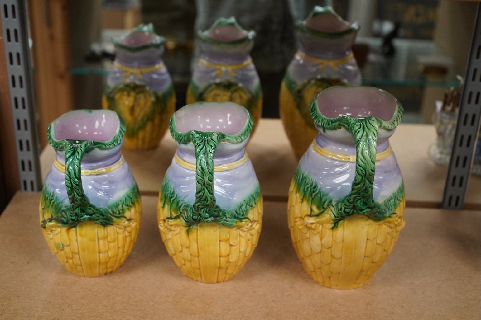 A graduated set of three maiolica ram decorated jugs, tallest 23cm high.